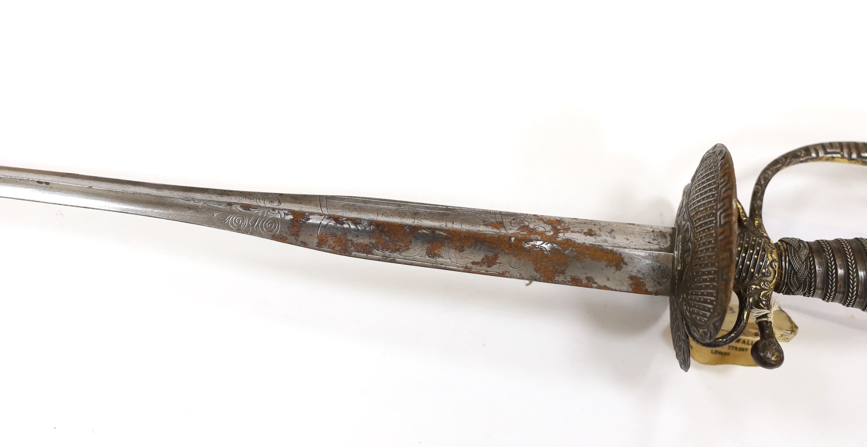A French iron hilted small sword, hilt with flutes and tiny gold dots, the knuckle guard with key decoration, iron tape and silver wire bound grip, colichemarde blade with etched strapwork decoration, c.1770, blade 83cm